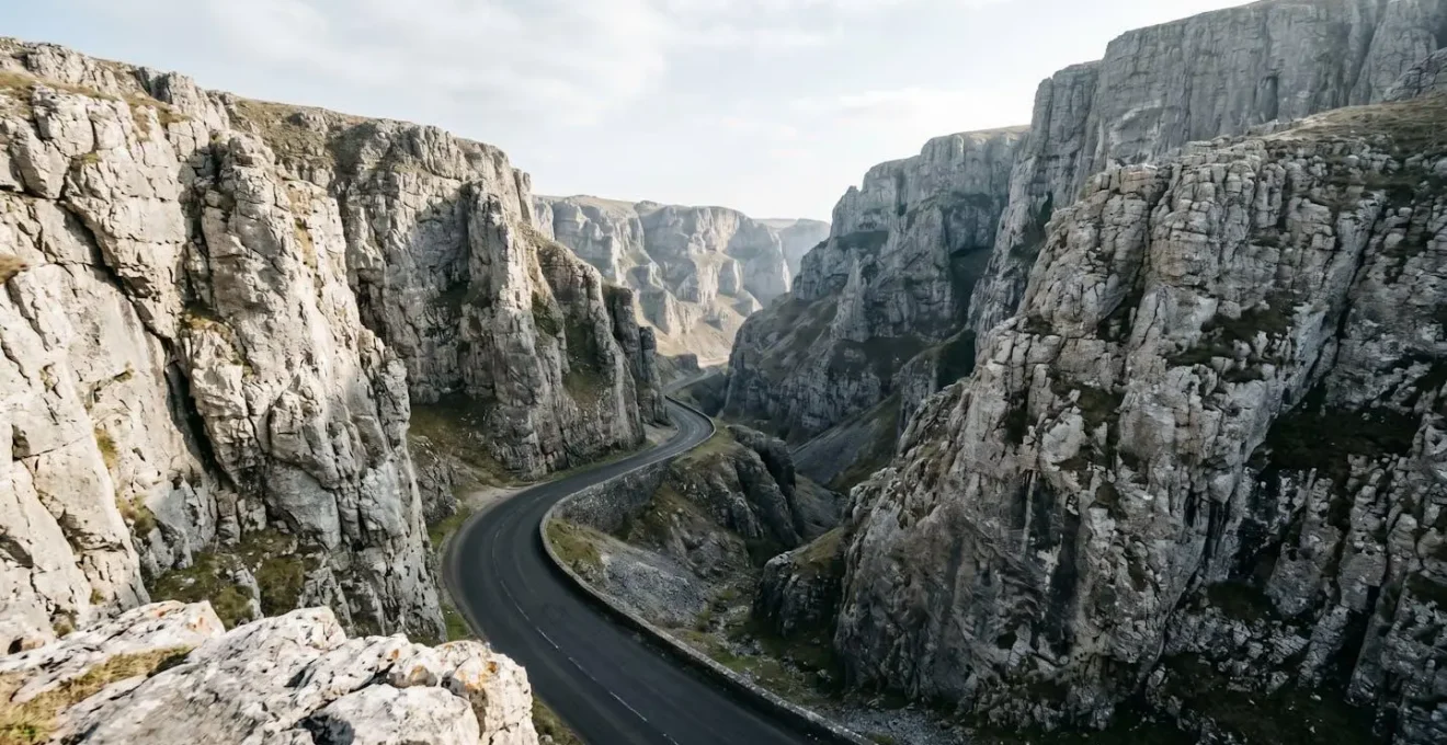 Towering limestone cliffs flanking a winding gorge road through dramatic UK landscape