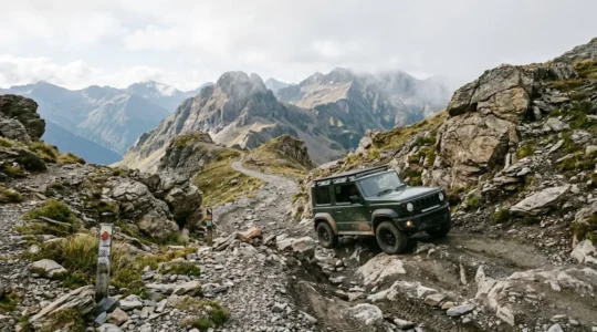 Four-wheel drive vehicle navigating steep rocky mountain trail with dramatic terrain