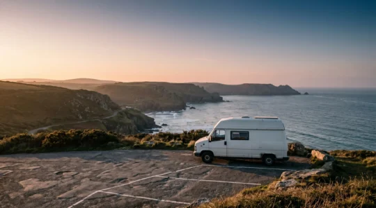 A campervan parked in a scenic UK coastal layby with distant hills and open sky, representing safe designated camping